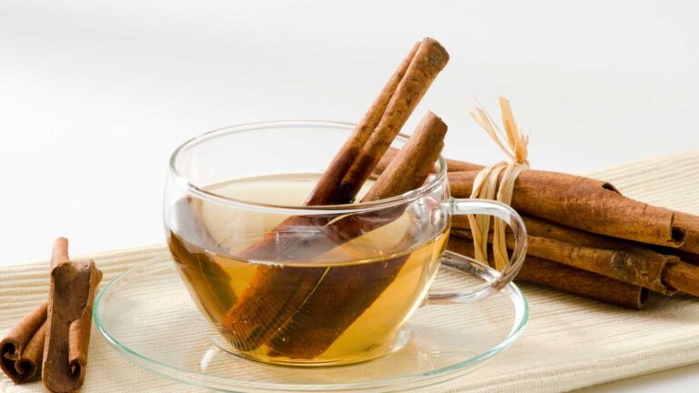 cinnamon tea in a glass cup, cinnamon sticks